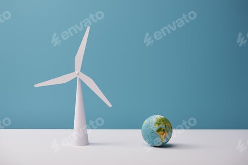 Preview: small globe and windmill model on white table and blue background