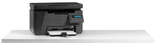 Preview: Office printer on a table while a document is being printed in a workspace