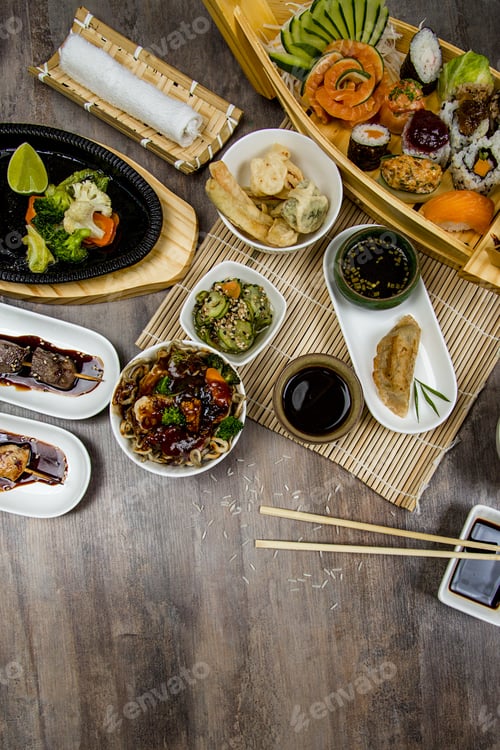 Preview: Vertical high angle shot of different Asian dishes on a wooden table
