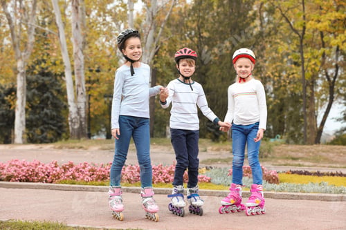 Preview: Happy children wearing roller skates in autumn park