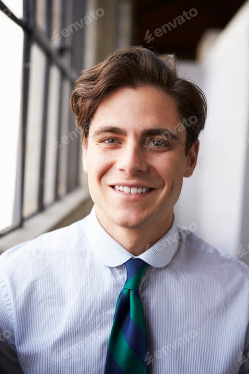 Preview: Young white businessman smiling, vertical portrait