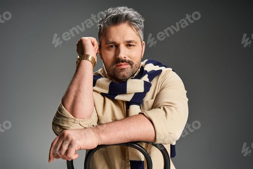 Preview: Handsome man in stylish outfit poses confidently in a trendy studio setting