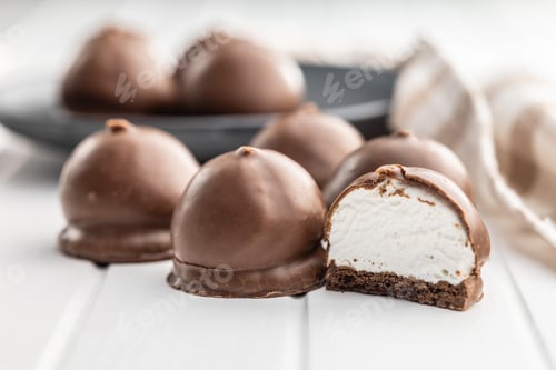 Preview: Chocolate covered marshmallows. Sweet dessert on white table.