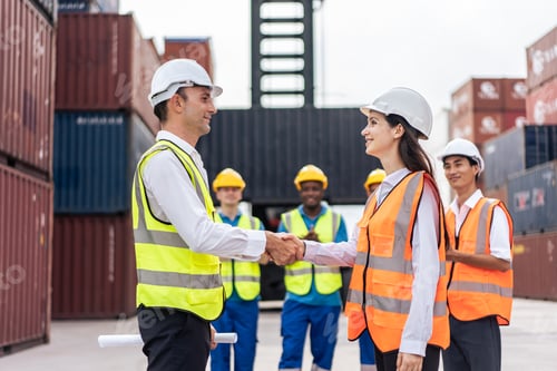 Preview: Caucasian business male and female shake hand in container terminal.