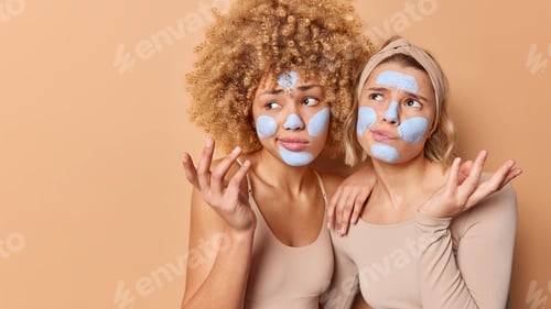 Preview: Hesitant confused young women shrug shoulders feel unaware apply beauty mask face difficult question