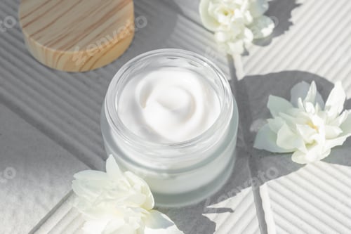 Preview: Spa concept. Cream in a glass jar with jasmine flowers on whiteconcrete background. copy space.
