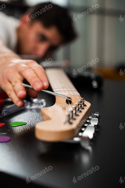 Preview: Guitar Adjustment with Hex Key. Guitarist uses a hex key to adjust bridge saddles and string height