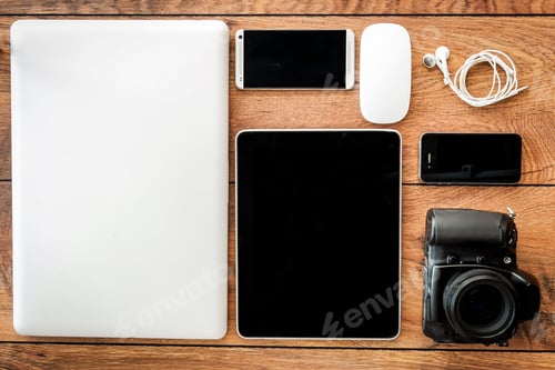 Preview: Up to date technology. Top view of diverse personal accessory laying on the wooden grain