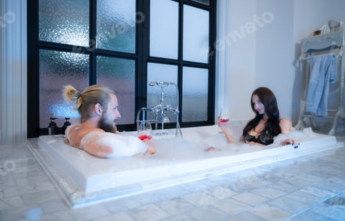 Preview: Beautiful young couple relaxing in bathtub at luxury spa resort.