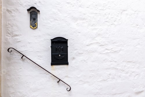 Preview: Rock wall painted in white with railing and two letter boxes for mediterranean style.