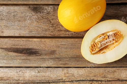 Preview: Cut and whole ripe melons on wooden table, top view. Space for text
