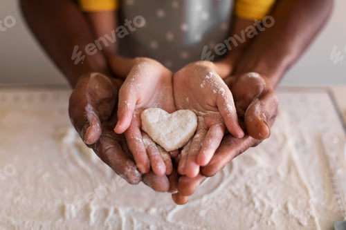 Preview: Black Father And Little Daughter Holding Heart Made Of Dough In Hands
