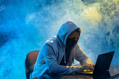 Preview: Hooded computer hacker stealing information with laptop