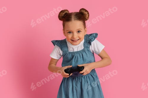 Preview: Excited Little Girl Playing Video Games With Joystick Over Pink Background