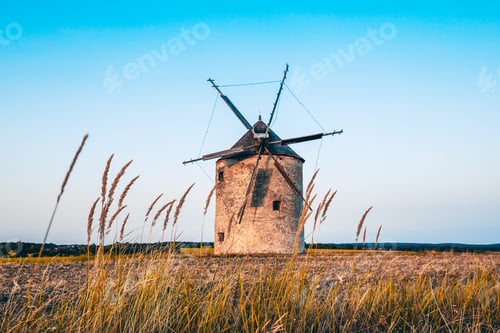 Preview: Windmill in a picturesque rural setting surrounded by lush green grass