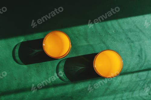 Preview: Summer creative photography with sunlight and shadows of orange juice.