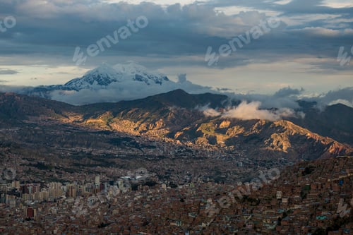 Preview: Sunset rays casting a warm glow over a mountainous cityscape