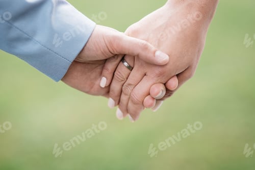 Preview: Closeup of the bride and groom holding hands with rings at a wedding