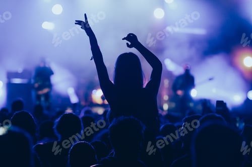 Preview: Silhouette of a woman with raised hands on a concert