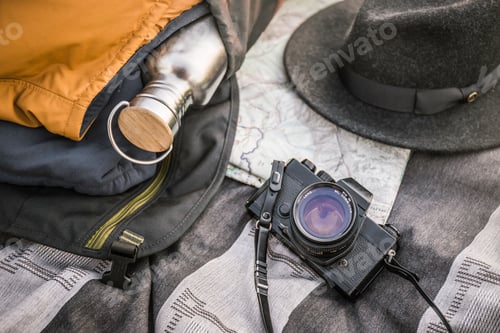 Preview: Still life of blanker, SLR camera, drinking flask and hat