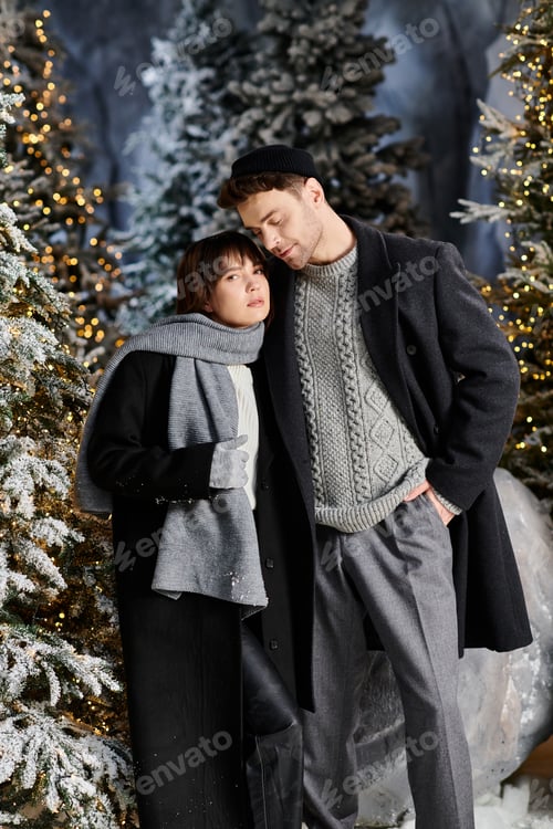 Preview: Couple in winter coats sharing warmth among snow-covered pines for Christmas joy