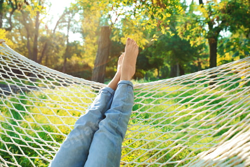 Preview: Young woman resting in comfortable hammock at green garden, closeup