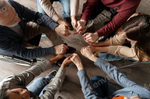 Preview: Diverse group of people holding hands in circle during support meeting