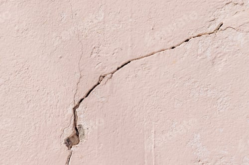 Preview: Close-up of crack on light pink plastered concrete wall