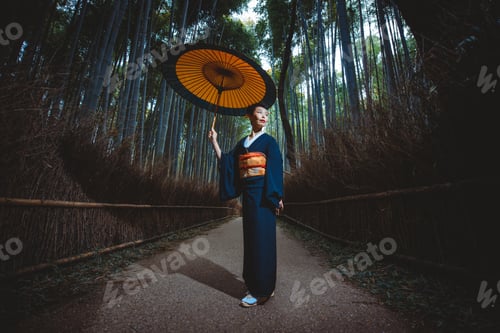 Preview: Beautiful japanese senior woman walking in the bamboo forest