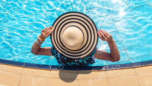 Preview: Woman in a hat in a swimming pool. Selective focus.