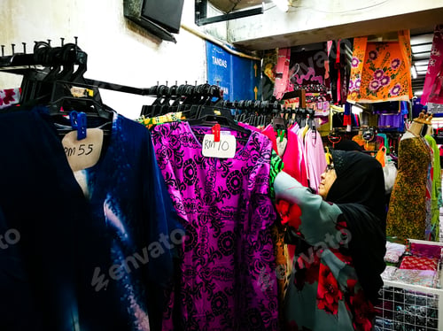 Preview: senior woman wearing hijab shopping at the local market