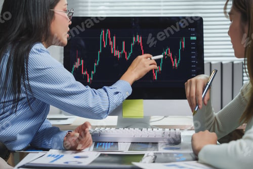 Preview: Businesswomen analyzing financial charts on computer screen