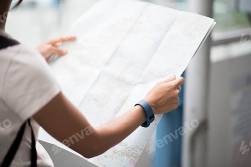 Preview: Female tourist with city map looking destination