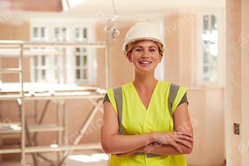 Preview: Portrait Of Smiling Female Builder Wearing Hard Hat Working In New Build Property