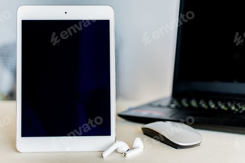 Preview: Tablet with black screen next to a laptop on a desk - technology and business concept