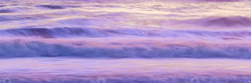 Preview: ocean waves crashing into the shore with some purple and yellow light
