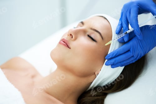 Preview: Beautiful young woman getting acid face treatment at beauty salon.
