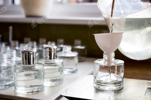 Visualização: Close-up da pessoa derramando líquido para difusor de perfume em garrafa de vidro.