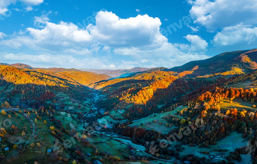 Preview: Shaded mountain valley with houses and forests at sunset