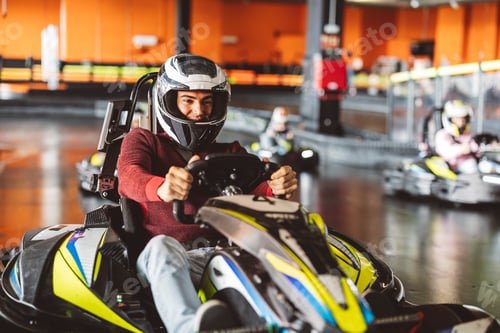 Preview: Young Man Leading a Group in Indoor Go-Kart Race