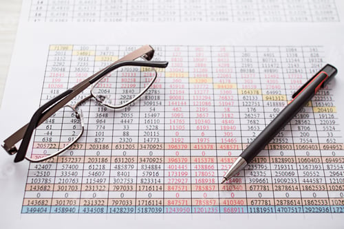 Preview: A table with numbers, glasses and a pen are on the table.