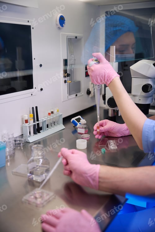Preview: Male and Female embryologists performing lab task with coordinated precision