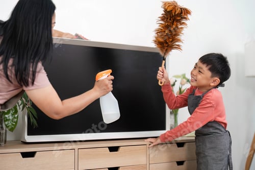 Preview: Family Cleaning and Home Care. A mother and son joyfully cleaning a TV stand together.