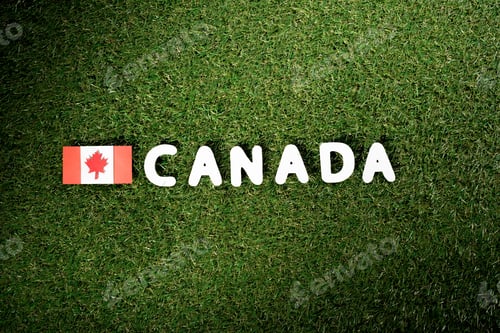 Preview: top view of word 'Canada' with canadian flag on green grass background