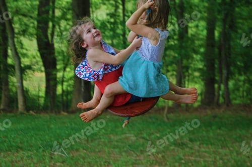 Preview: Pure Joy: Minimalist image, cousins sharing a swing on a summer day surrounded by lush forest trees.