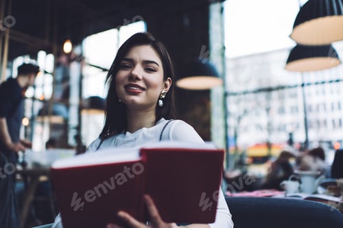 Preview: Smiling woman with notebook in cafeteria