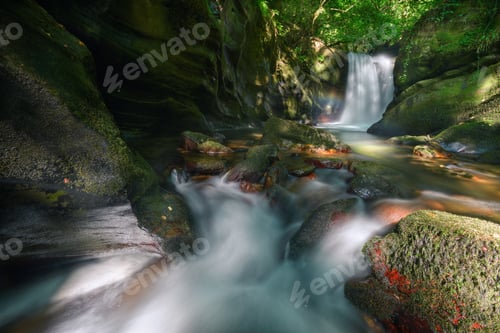 Vorschau: Bach und Wasserfall mit kleinem Regenbogen zwischen erodierten Kalksteinfelsen