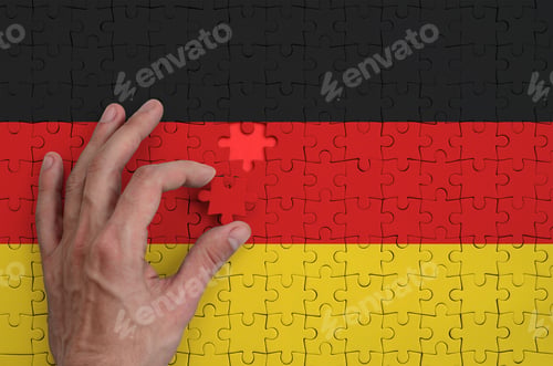 Preview: Germany flag is depicted on a puzzle, which the man's hand completes to fold.