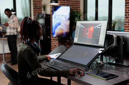Preview: Game developer sitting in creative agency office workspace while designing game level