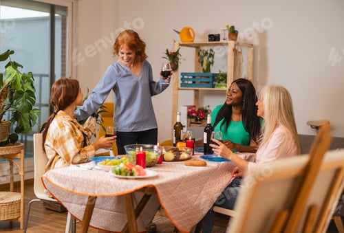 Preview: Woman Standing and Toasting at a Friendly Dinner Gathering